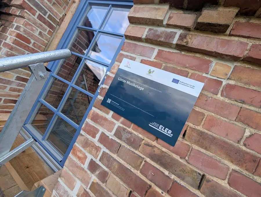 Förderschild mit EU- und ELER-Logo an der Backsteinwand der Musiketage